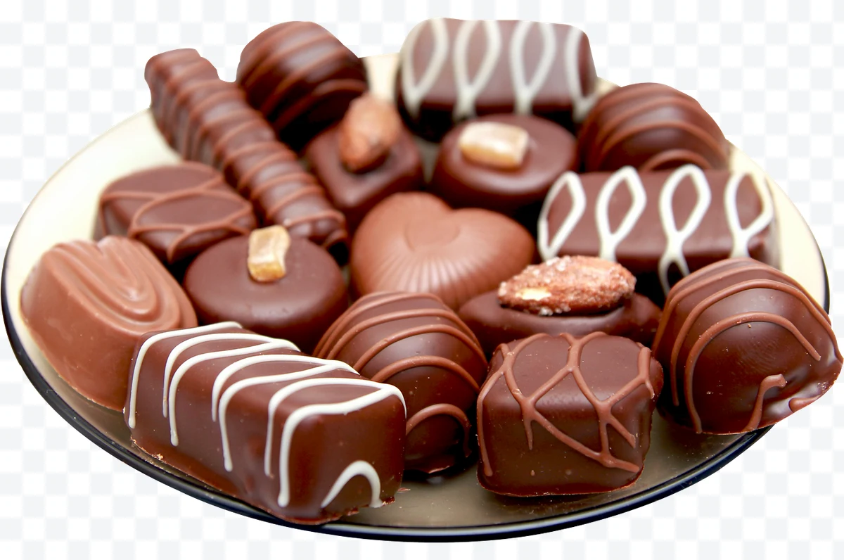 Plate with chocolate bonbons decorated with white glaze and chocolate and
