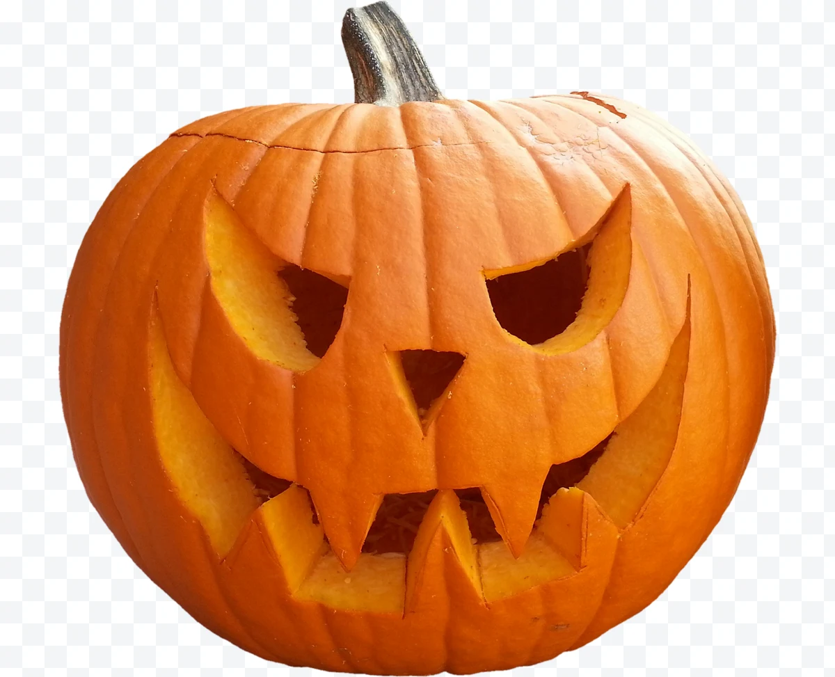 Halloween carved pumpkin with eyes and mouth shaped like a scary face