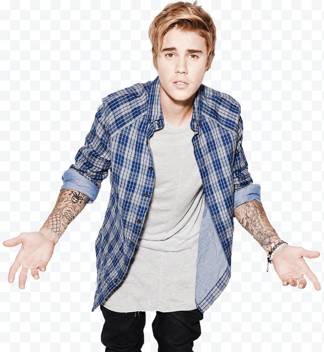 Justin Bieber in a blue plaid shirt, gray T-shirt, and tattoos on his arms.
