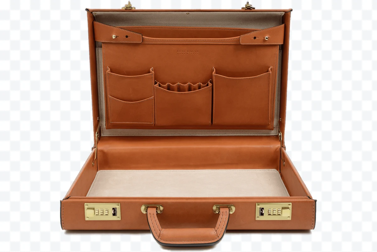 Open brown Korchmar leather briefcase with internal pockets and locks