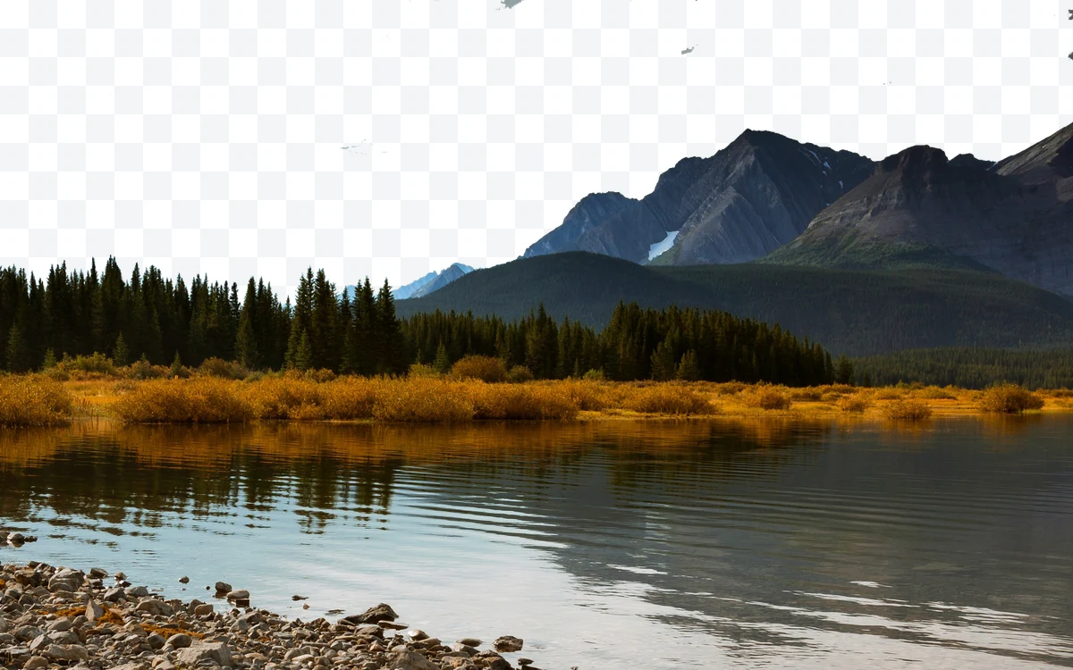 Mountain landscape with lake, conifer trees, and reflection in the water.
