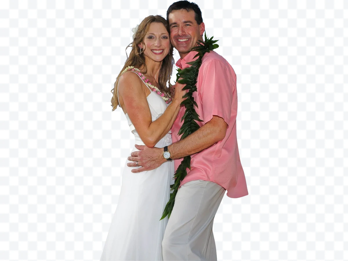 Couple hugging, woman in white dress and man in pink shirt with garland