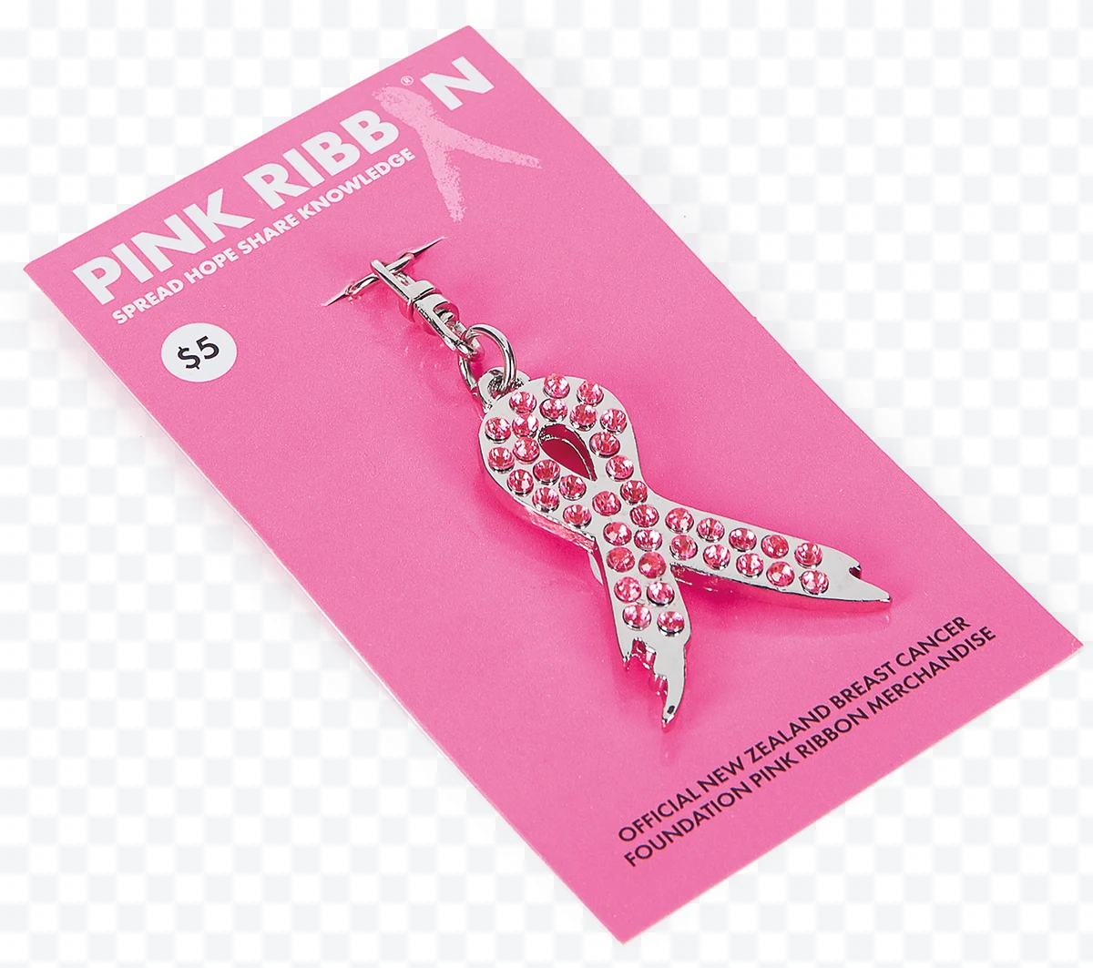 Pink ribbon pin with pink crystals on a pink card with text