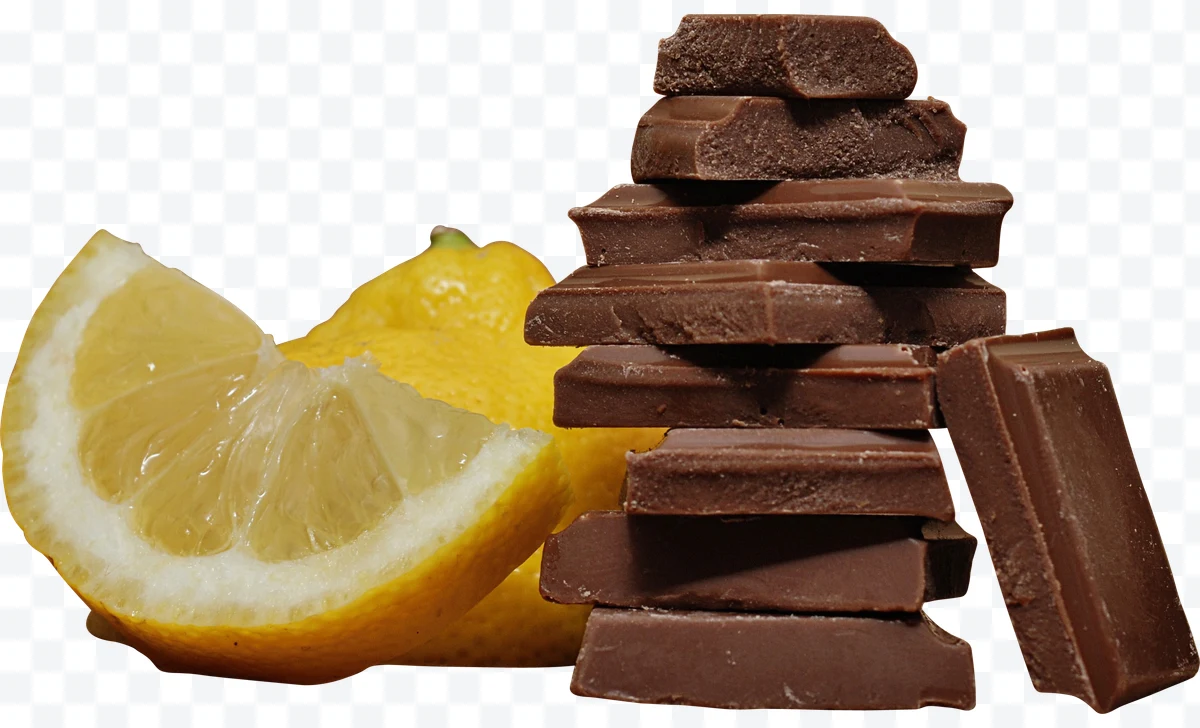 Stacked chocolate pieces next to a lemon slice.