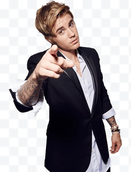 Justin Bieber señalando con tatuajes visibles y blazer negro sobre camisa blanca