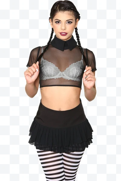 Mujer con trenzas y ropa negra con medias a rayas posando de frente