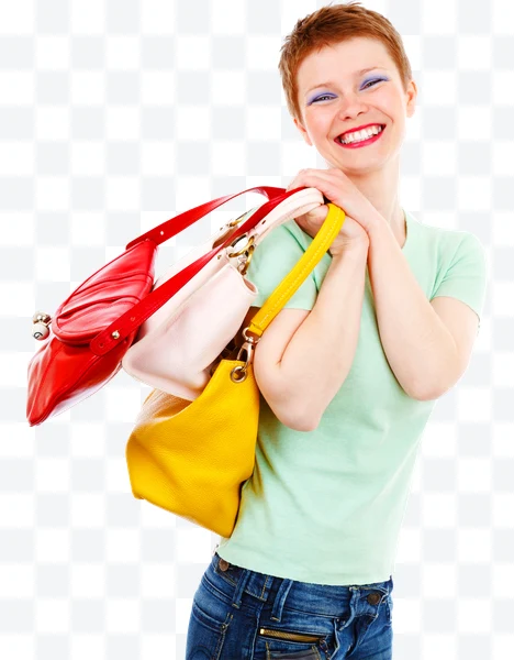 Mujer sonriente con camiseta verde claro y jeans azules con tres bolsos de