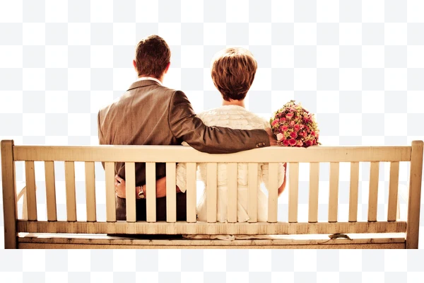 Pareja sentada en un banco con ramo de flores